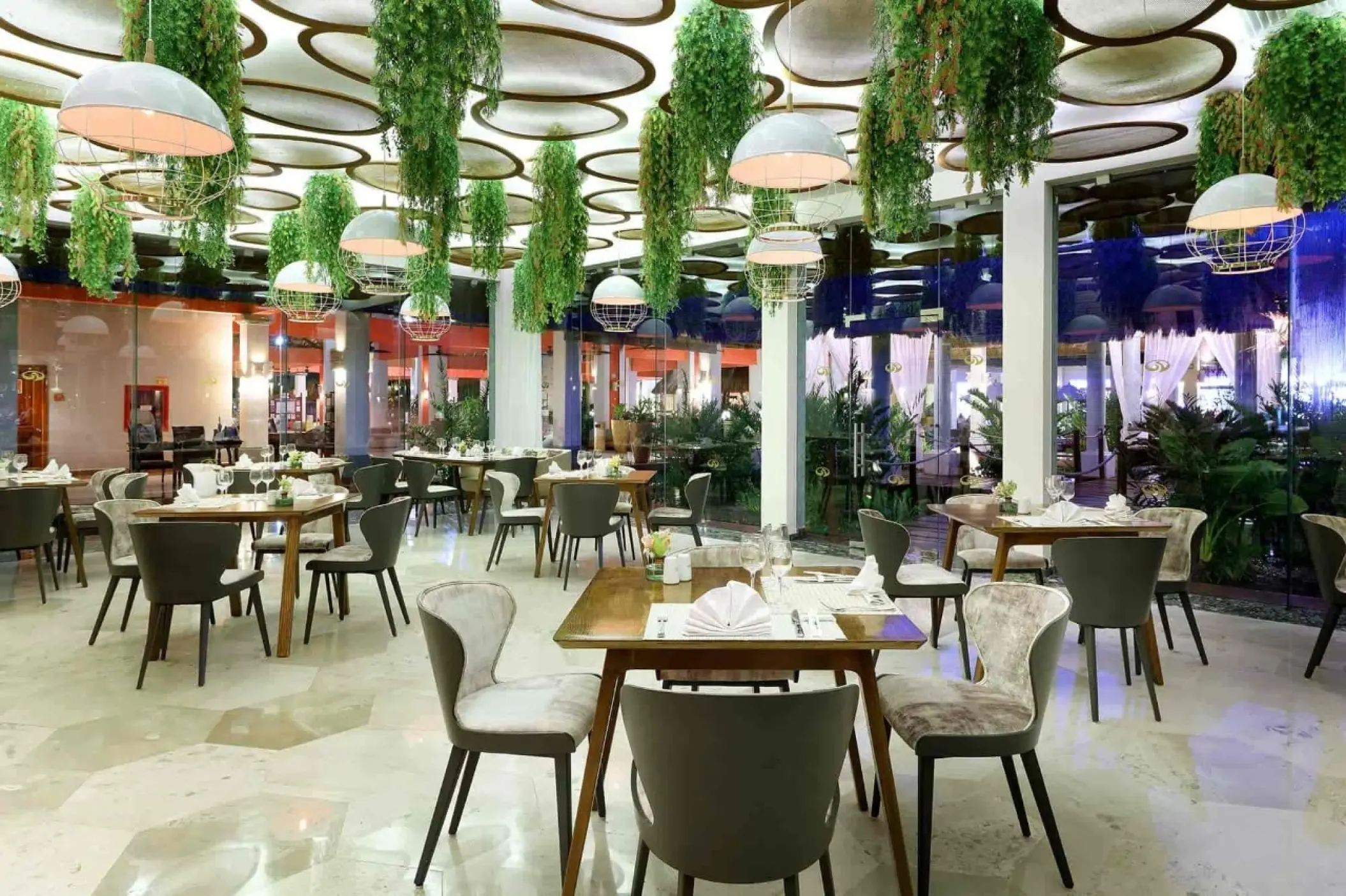 Upscale dining room with hanging plants and circular ceiling lights at Grand Palladium Kantenah, Riviera Maya