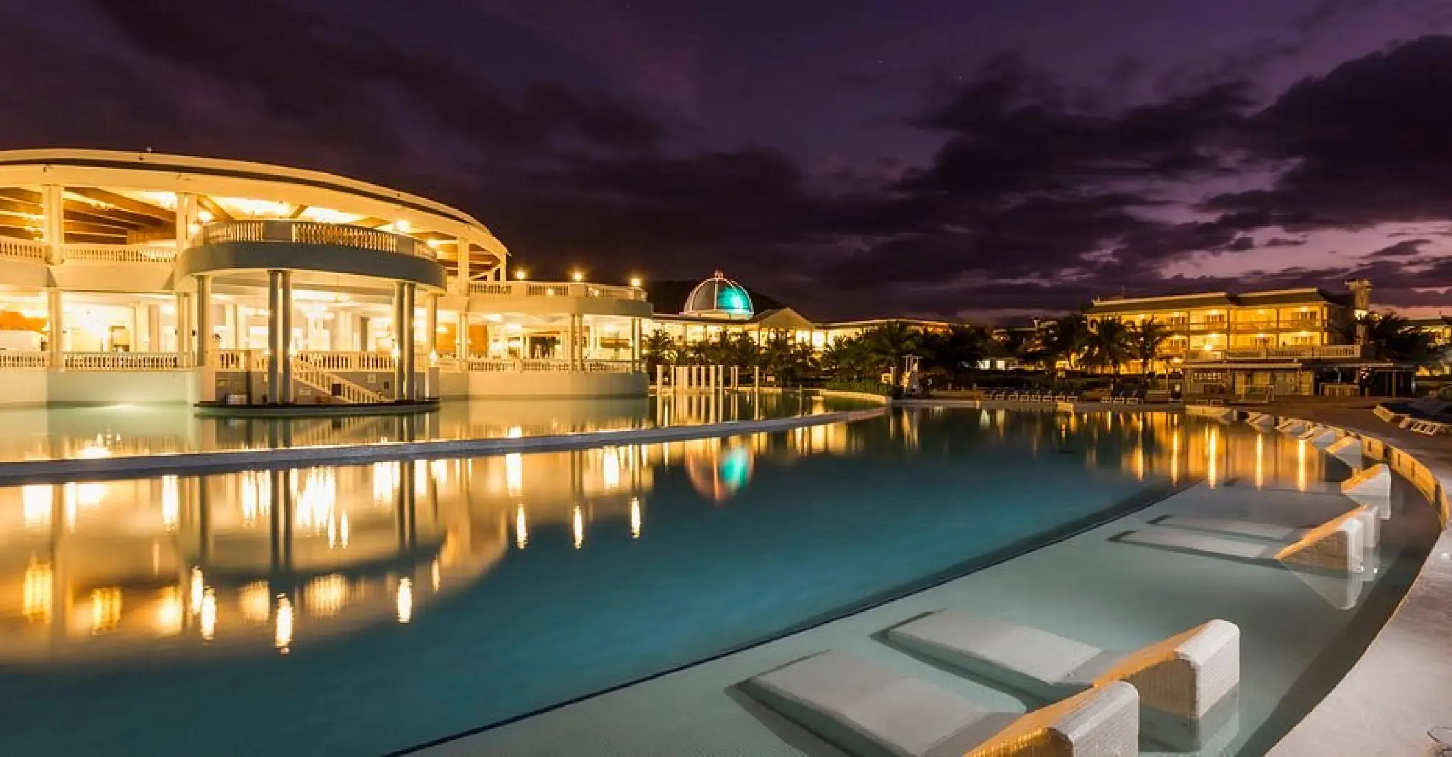 Grand Palladium Lady Hamilton infinity pool and lit buildings at night, Ocho Rios