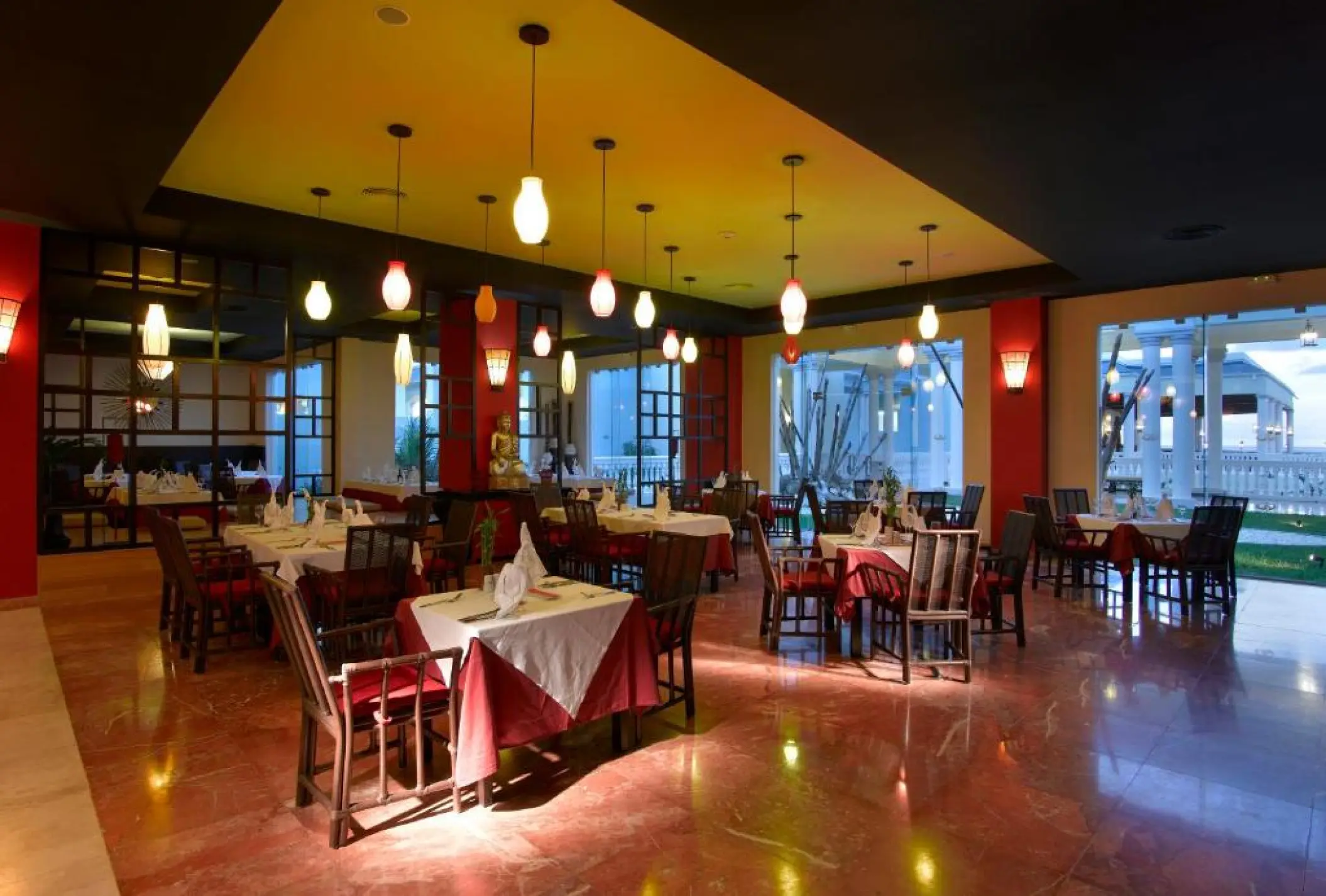 Indoor restaurant dining area with hanging pendant lights at Grand Palladium Lady Hamilton, Ocho Rios