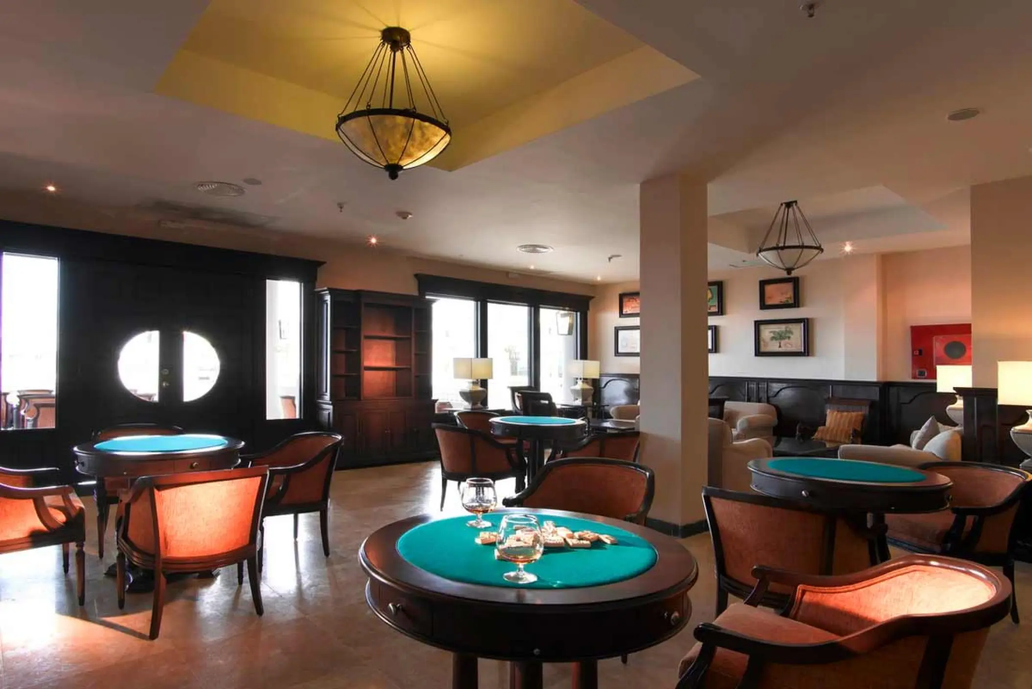 Sports bar interior with circular card tables and lounge seating at Grand Palladium Lady Hamilton, Ocho Rios