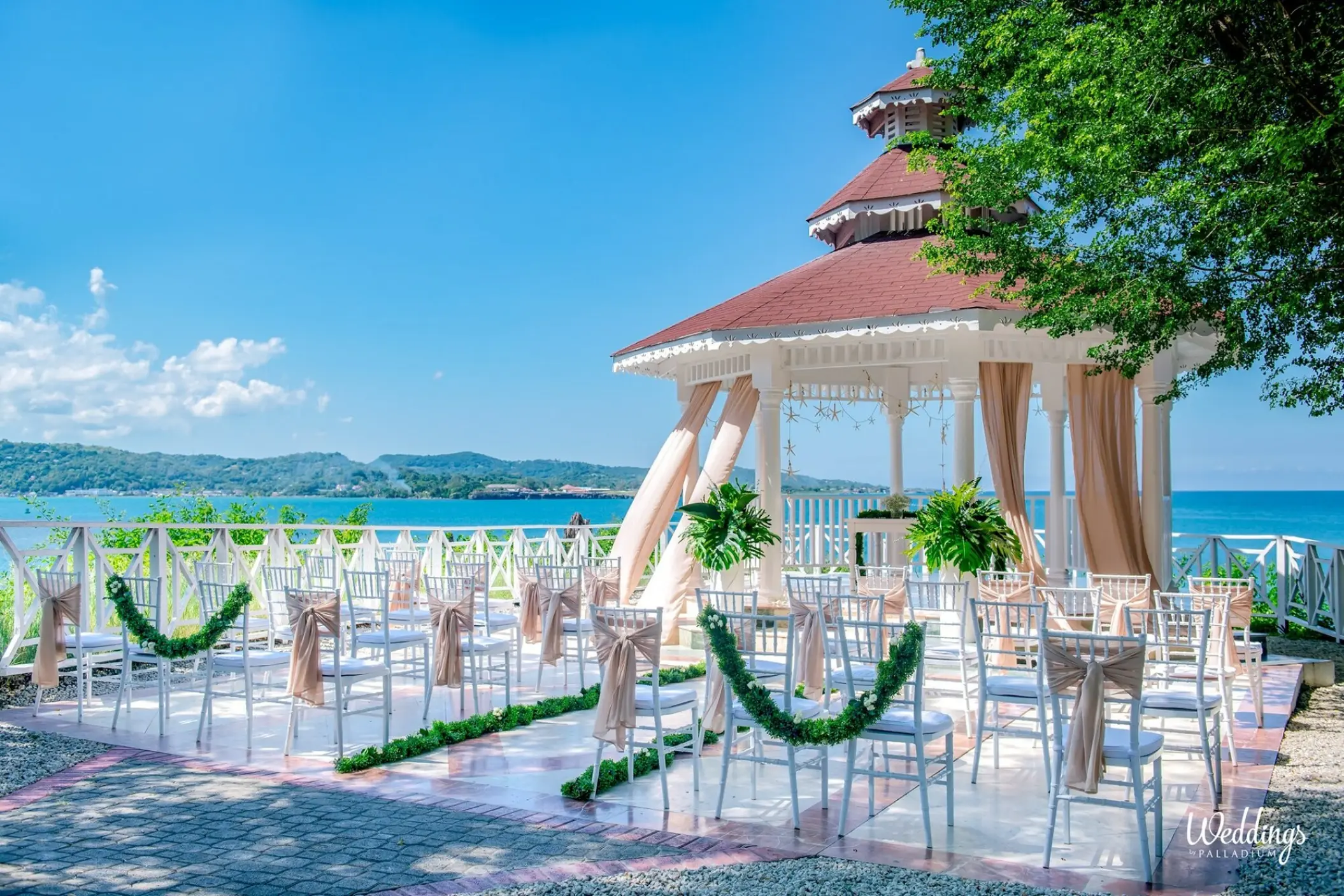 Oceanfront wedding ceremony gazebo with white chairs at Grand Palladium Lady Hamilton, Ocho Rios