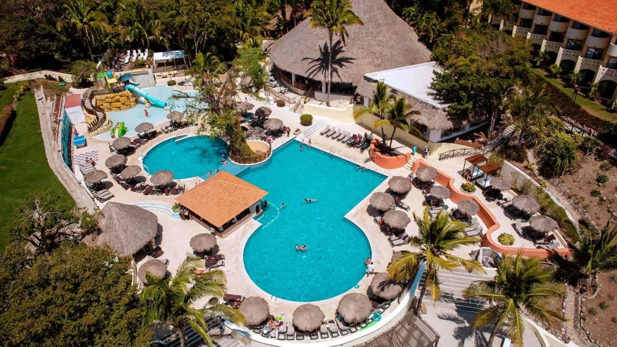 Aerial view of the main swimming pool complex surrounded by palm trees at Grand Palladium Vallarta, Puerto Vallarta