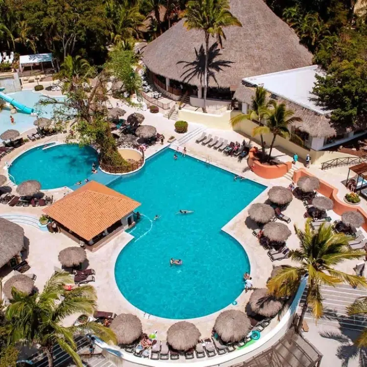Aerial view of the main swimming pool complex surrounded by palm trees at Grand Palladium Vallarta, Puerto Vallarta