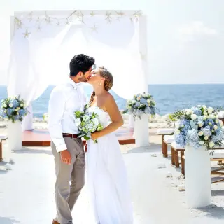 The couple kissing at an oceanfront beach ceremony at Grand Palladium Kantenah, Riviera Maya
