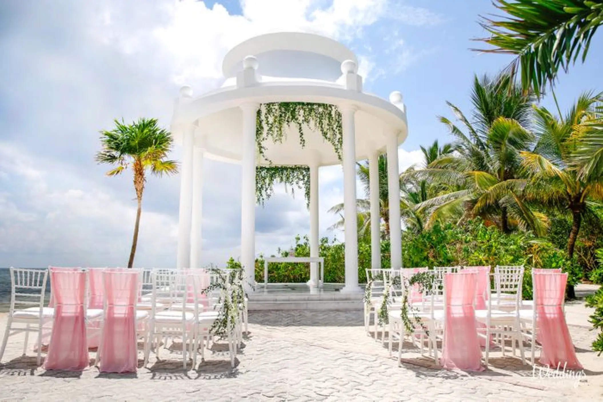 White wedding gazebo with pink chair sashes at Grand Palladium Colonial, Riviera Maya