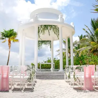 White wedding gazebo with pink chair sashes at Grand Palladium Colonial, Riviera Maya