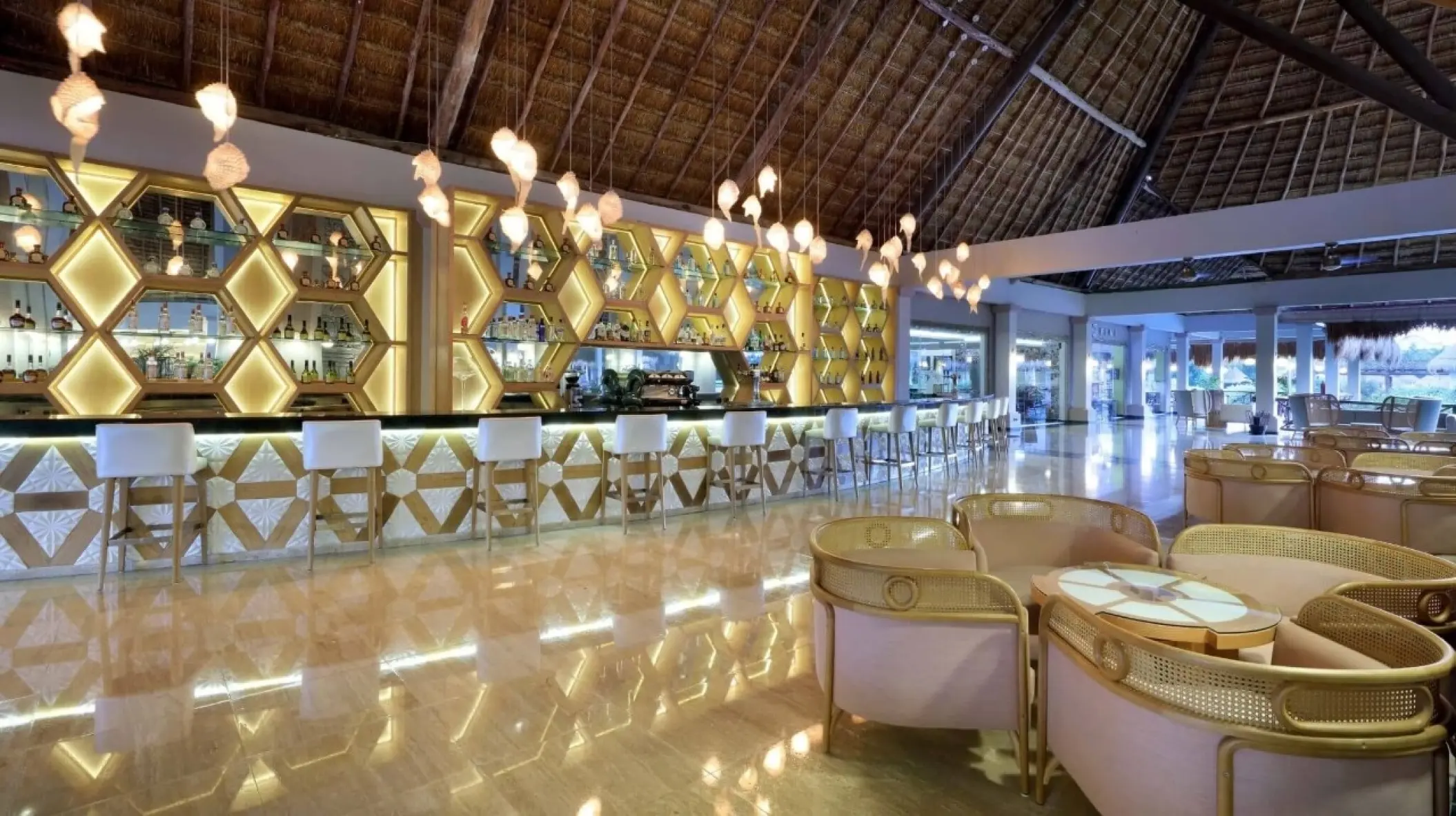 Modern bar and lounge area under a thatched palapa roof at Grand Palladium White Sand, Riviera Maya
