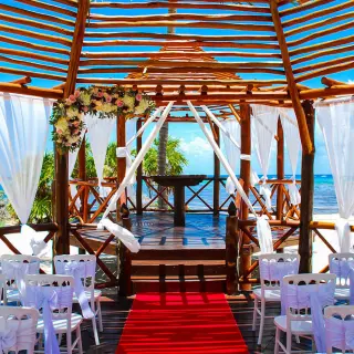Beachfront wedding ceremony setup with red carpet inside a wooden gazebo at Grand Riviera Princess, Playa Del Carmen