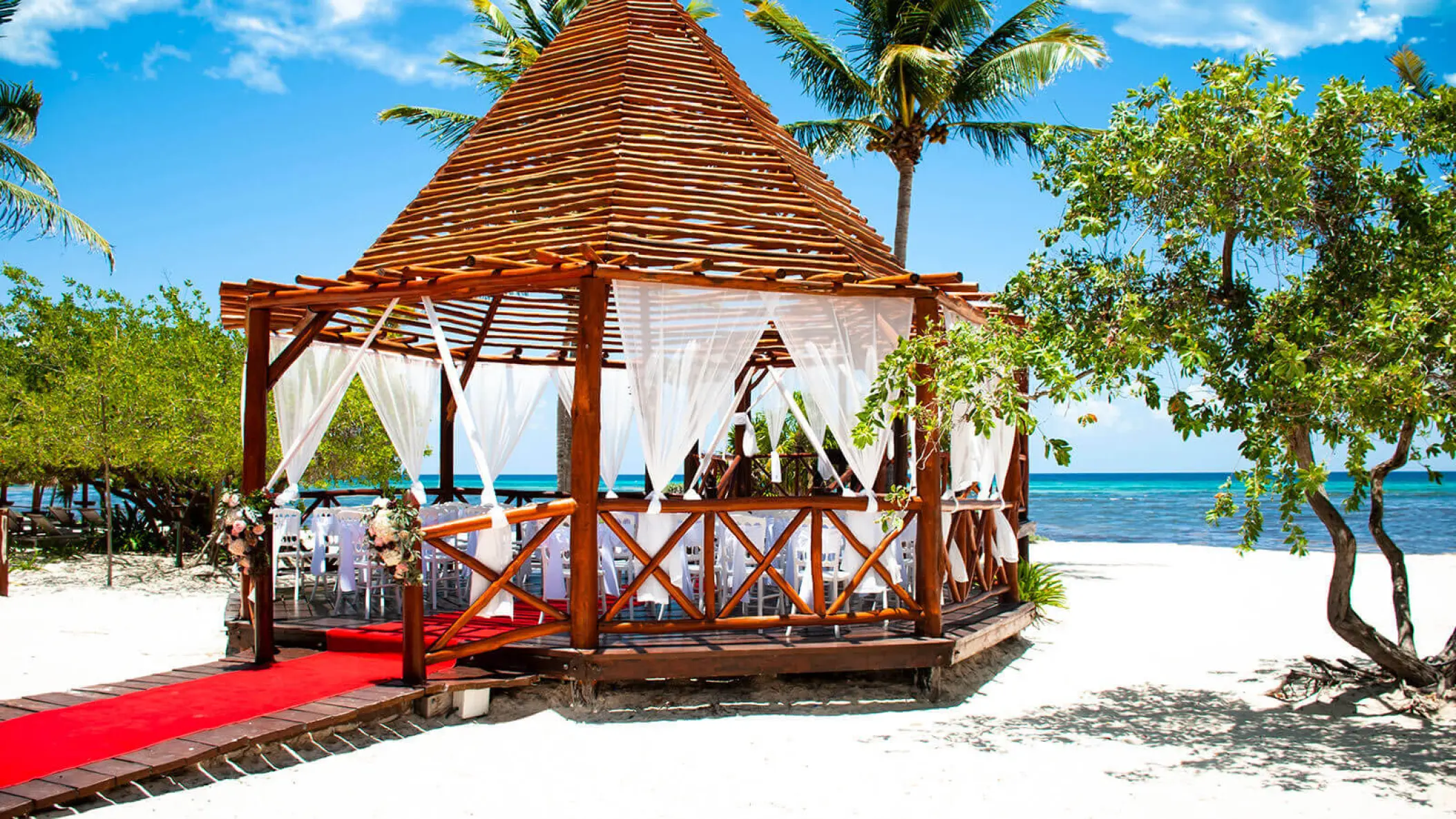 Beachfront wedding ceremony gazebo with red aisle runner at Grand Riviera Princess, Playa Del Carmen