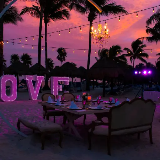 Beach wedding reception at Grand Riviera Princess, Playa Del Carmen with string lights and illuminated LOVE sign