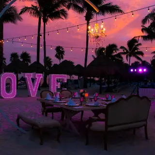 Beach wedding reception at Grand Riviera Princess, Playa Del Carmen with string lights and illuminated LOVE sign