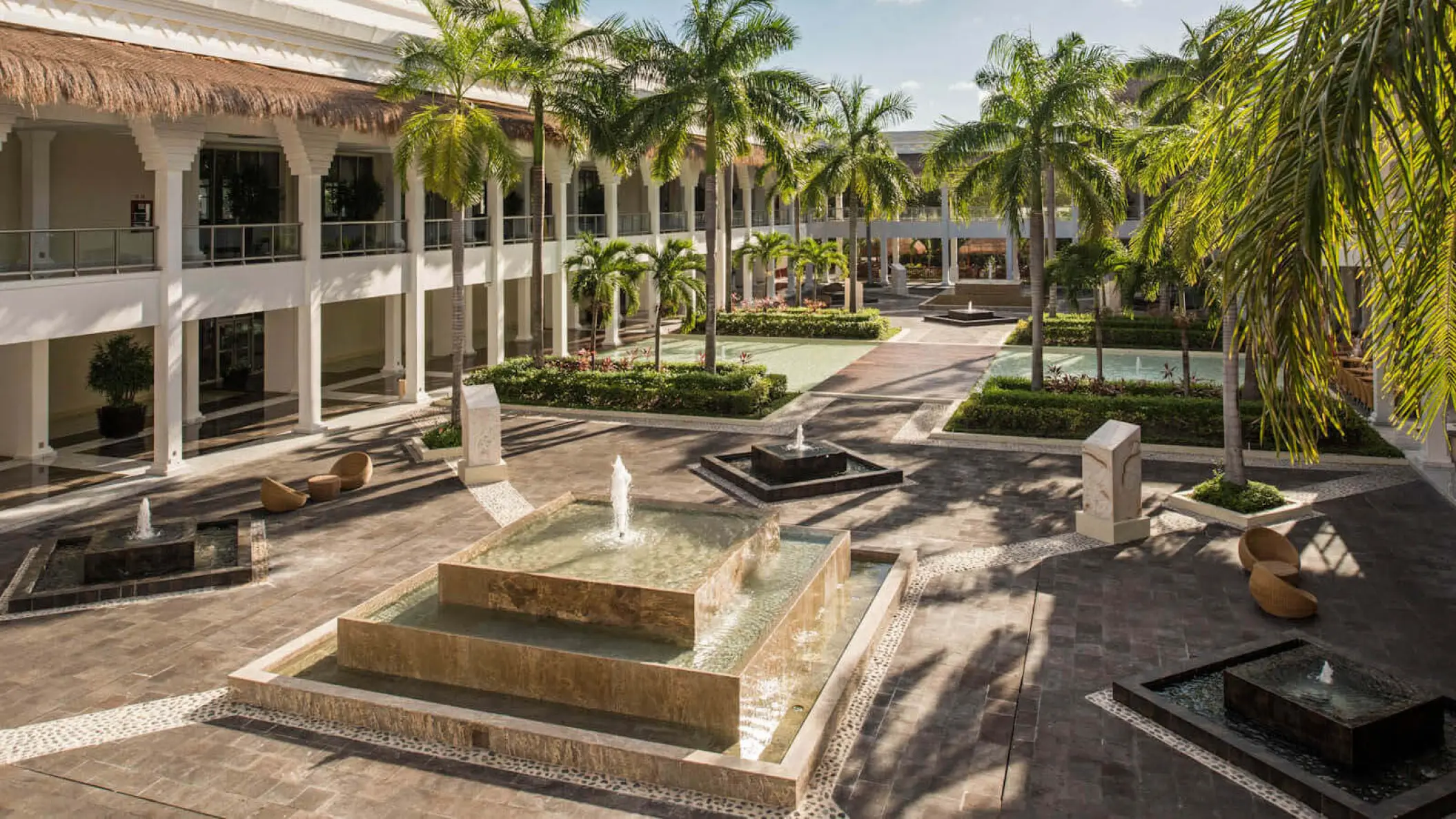 Grand Riviera Princess courtyard plaza with stone fountains and palm trees, Playa Del Carmen