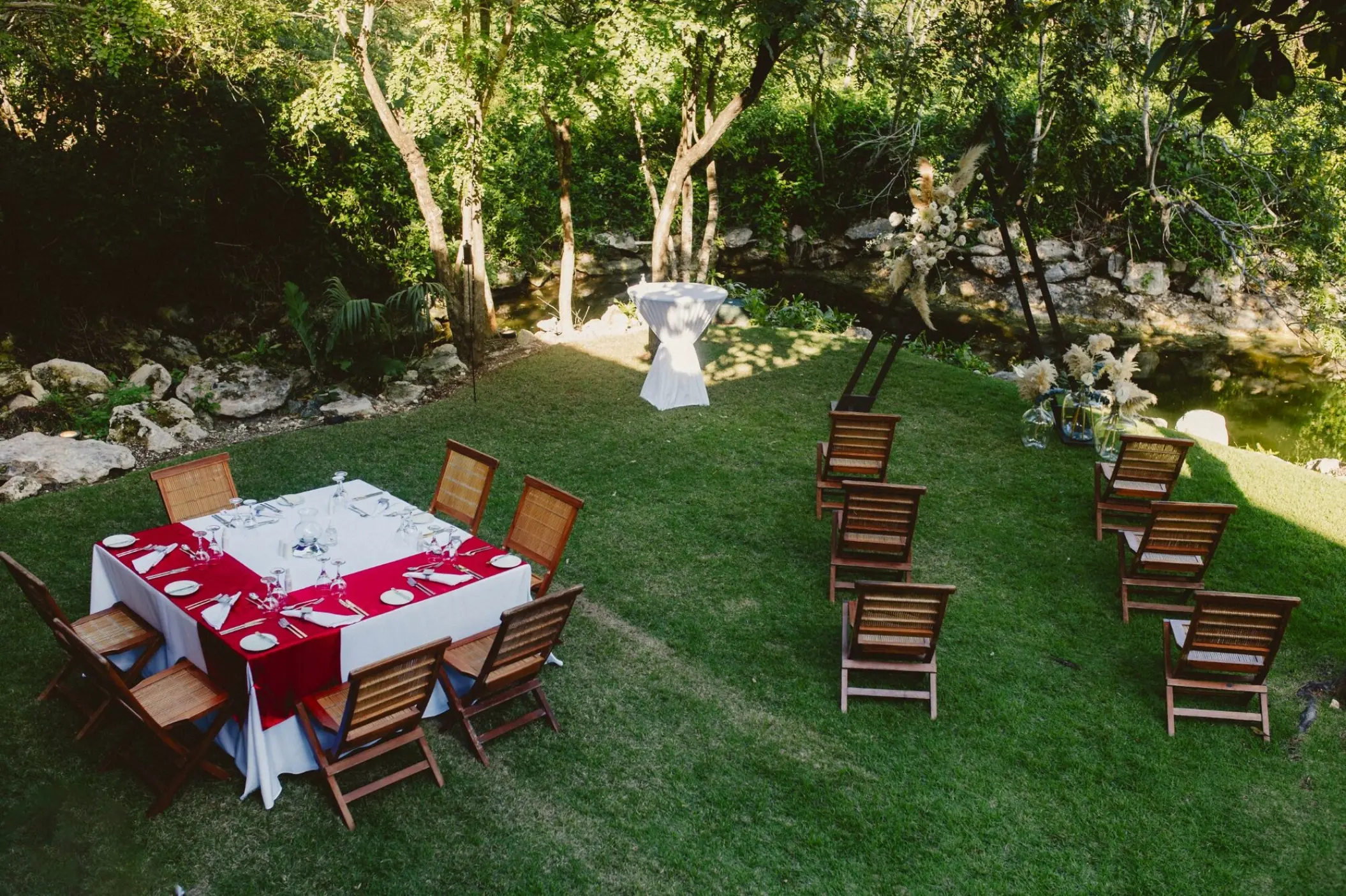 Garden wedding reception at Grand Velas Riviera Maya with a red and white table and wooden chairs