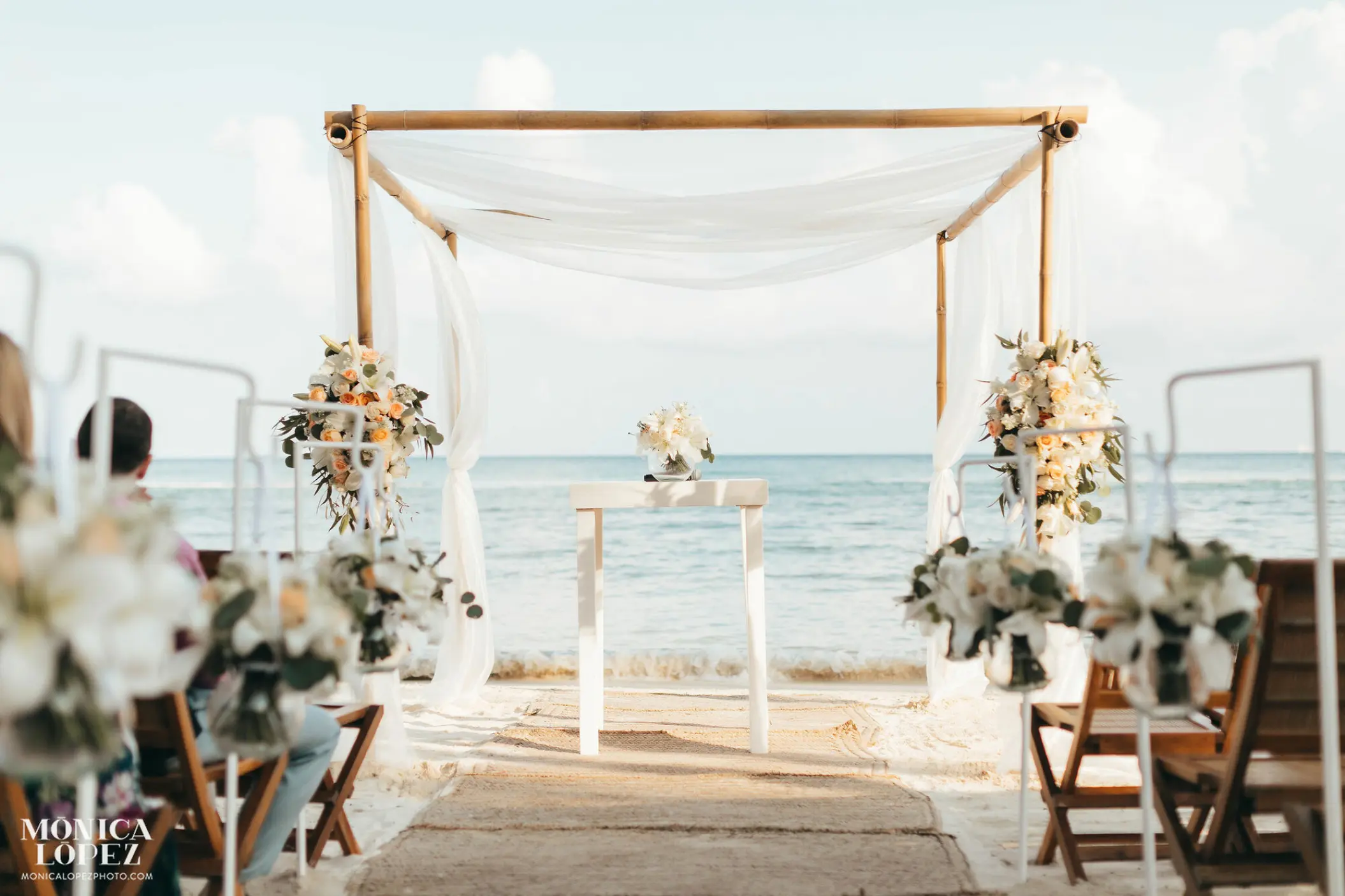 Bamboo beach ceremony arch with white fabric at Grand Velas Riviera Maya