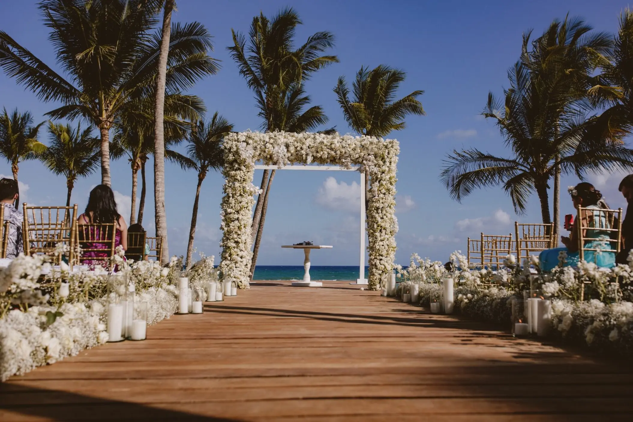 Deck wedding ceremony setup with white floral arch at Grand Velas Riviera Maya