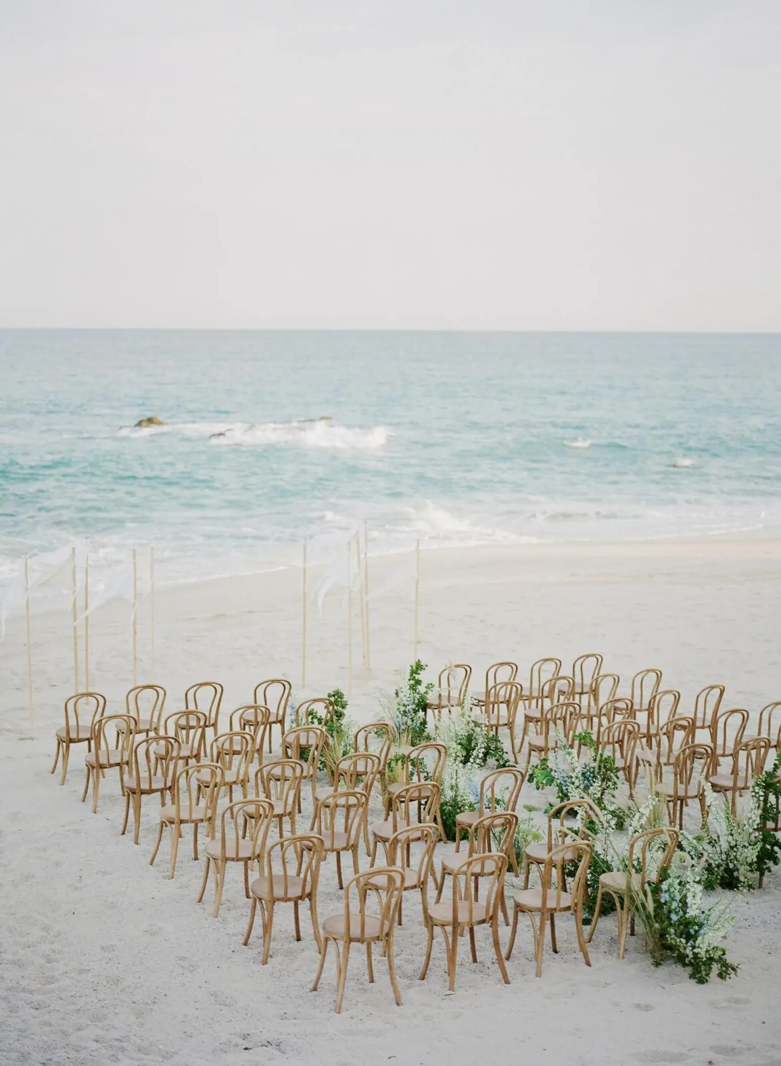 Beachfront wedding ceremony with wooden chairs at Grand Velas Los Cabos, Cabo San Lucas
