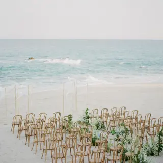Beachfront wedding ceremony with wooden chairs at Grand Velas Los Cabos, Cabo San Lucas