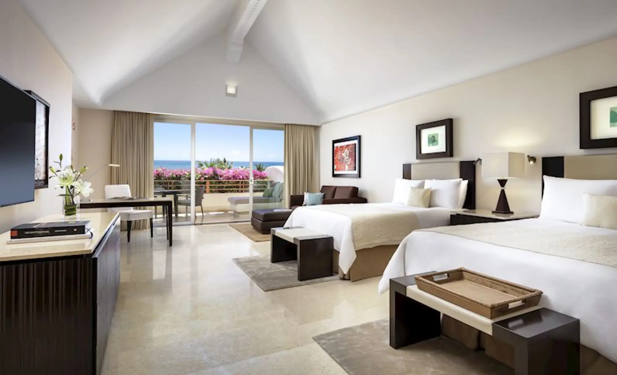 Modern guest room with two double beds and a private terrace at Grand Velas Riviera Maya