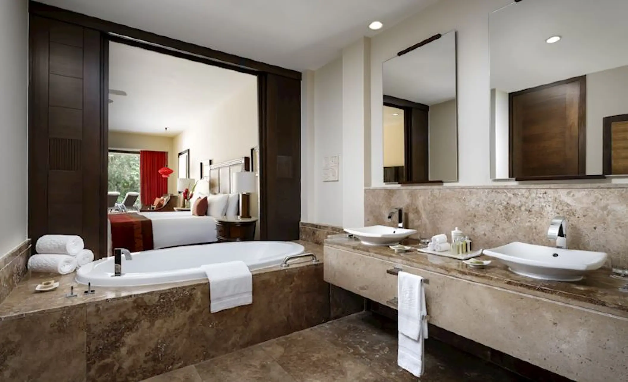 Luxury suite bathroom with a stone soaking tub and double vanity at Grand Velas Riviera Maya