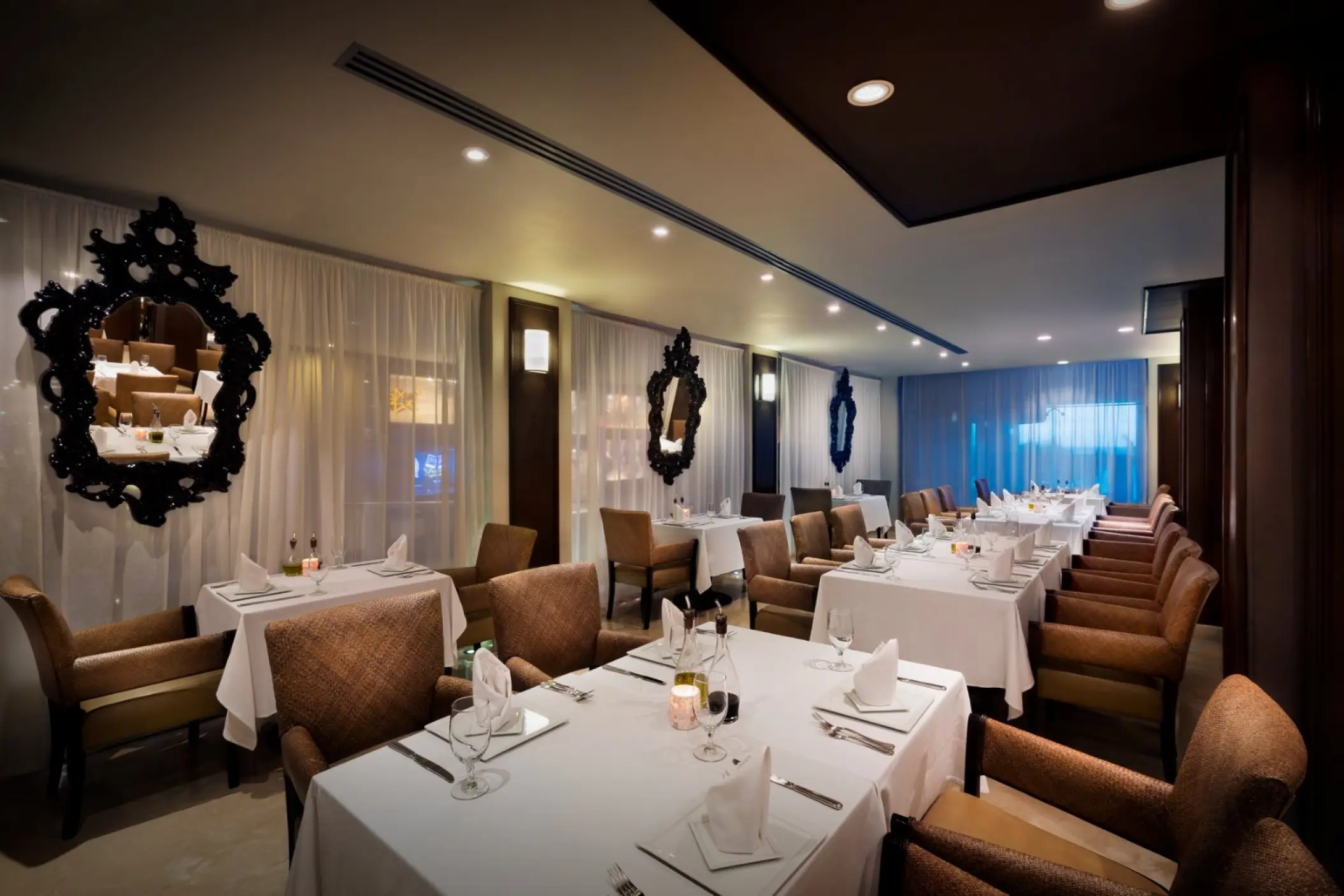 Ciao restaurant dining room with white tablecloths and ornate mirrors at Hard Rock Cancun