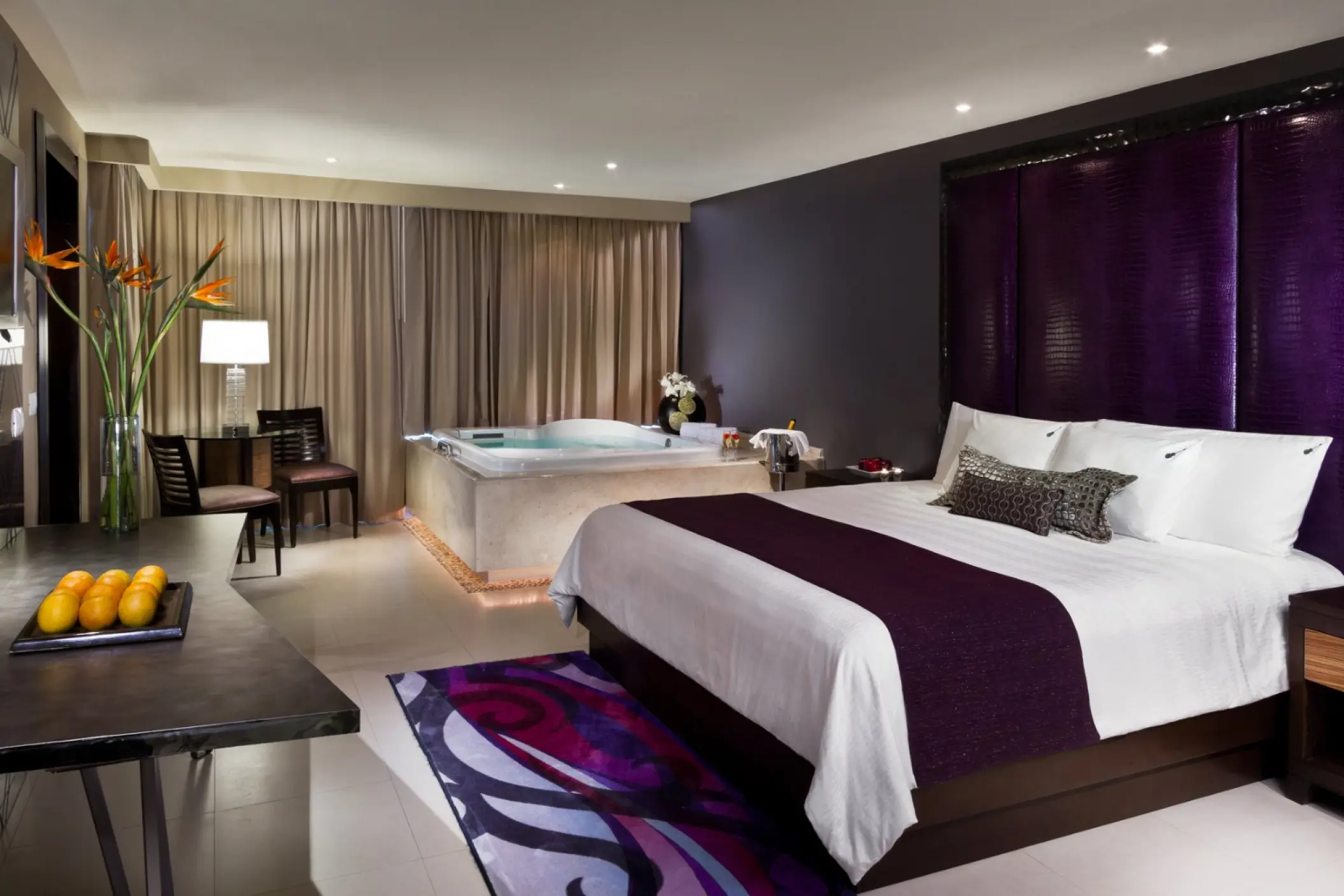 Hard Rock Cancun guest suite with a king bed, purple accents, and an in-room hydro spa tub, Cancun