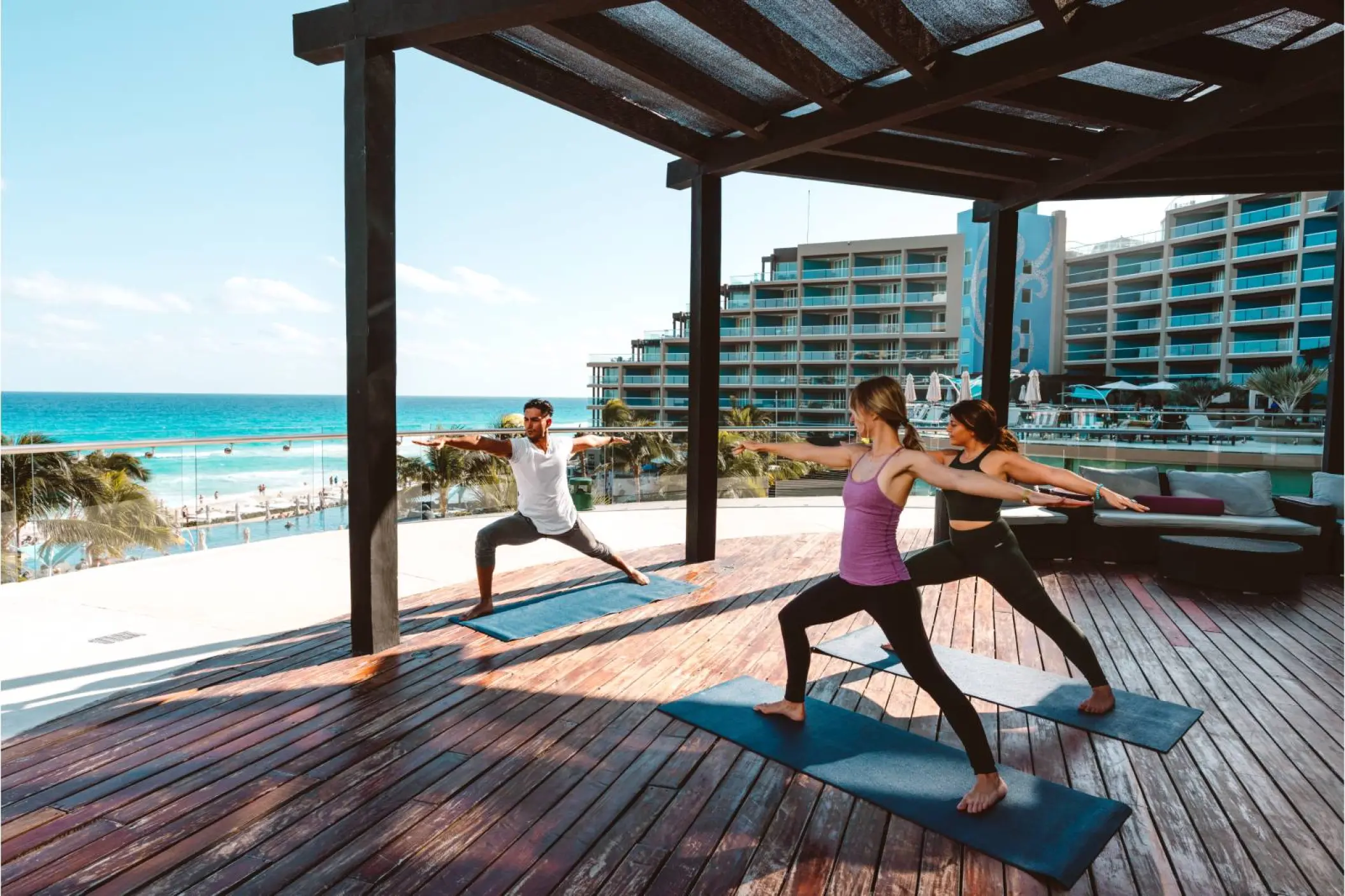 Yoga class on a wooden terrace overlooking the ocean at Hard Rock Cancun