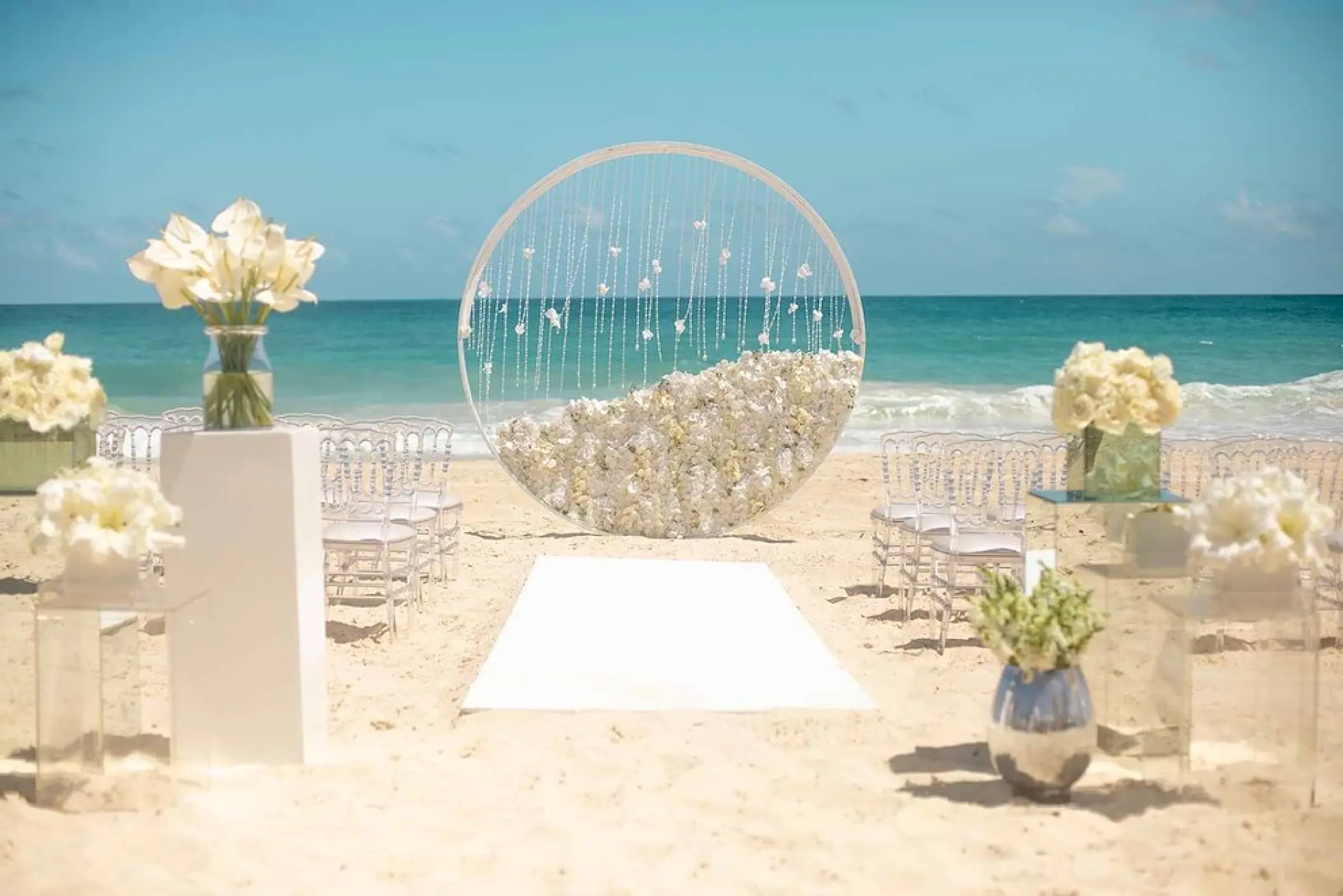 Beachfront wedding ceremony with circular floral arch at Hard Rock Cancun, Cancun