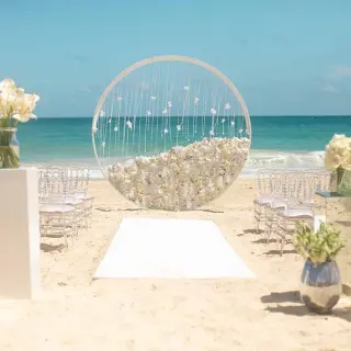 Beachfront wedding ceremony with circular floral arch at Hard Rock Cancun, Cancun