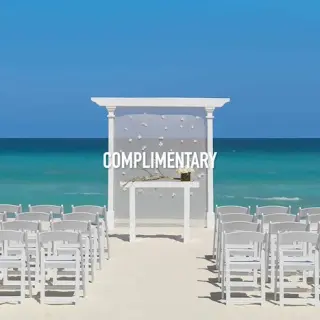 Beachfront wedding ceremony with white chairs and the text Complimentary at Hard Rock Cancun, Cancun