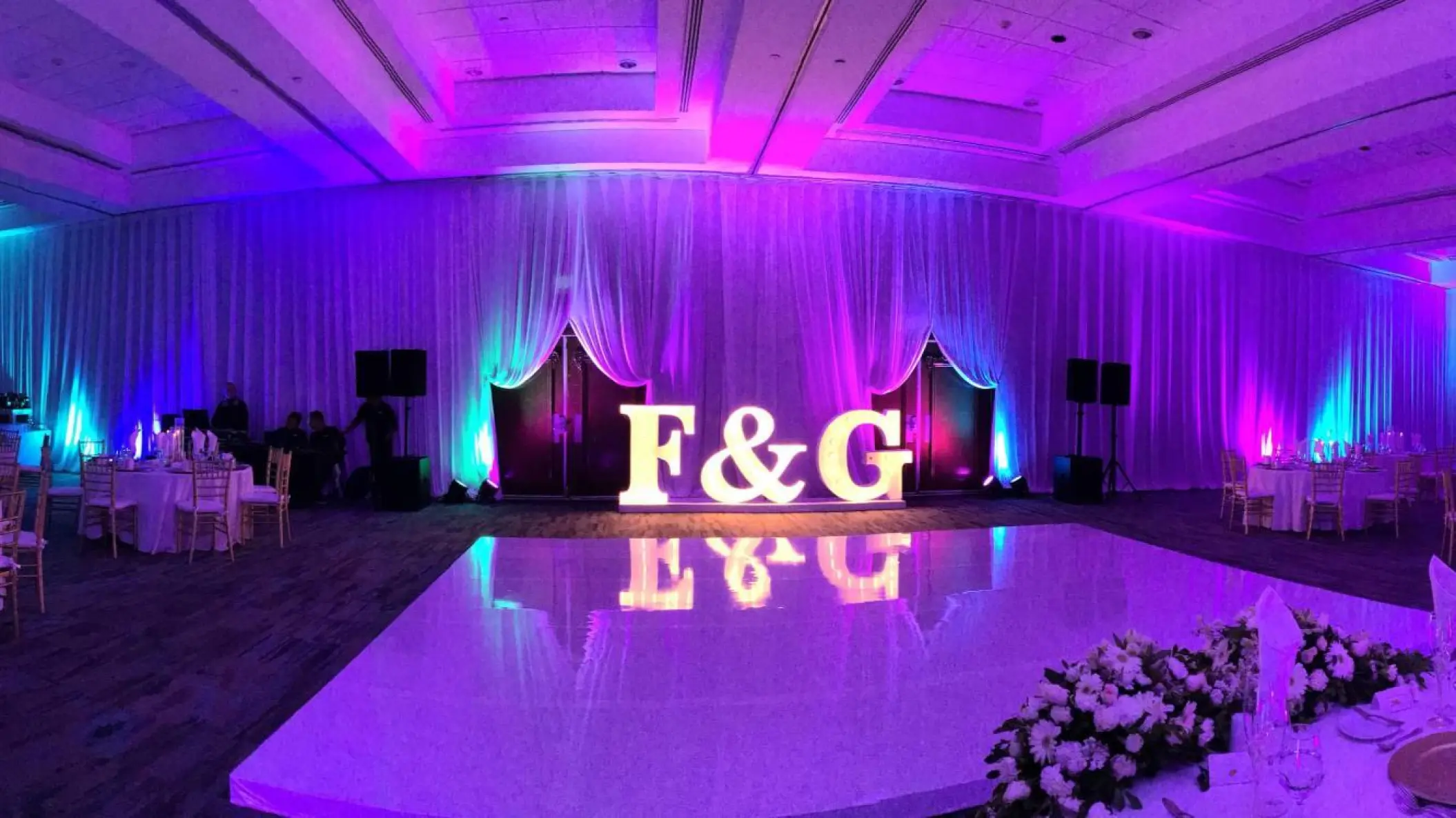 Indoor wedding reception at Hard Rock Cancun with a dance floor, purple lighting, and marquee initials