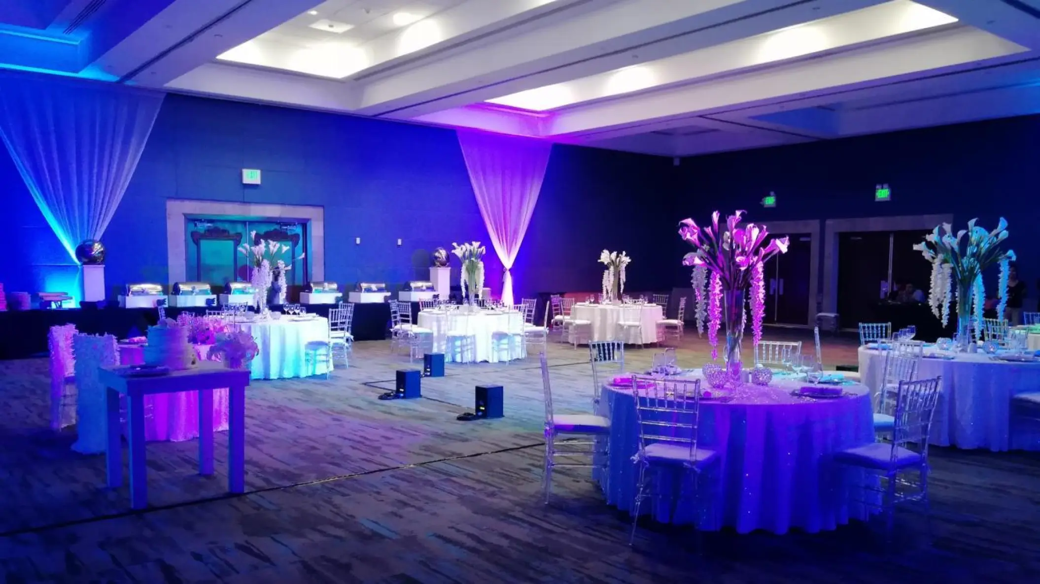 Indoor wedding reception with round tables and purple lighting at Hard Rock Riviera Maya