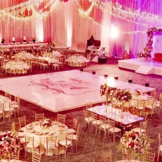 Indoor ballroom wedding reception at Hard Rock Cancun with white dance floor and floral centerpieces