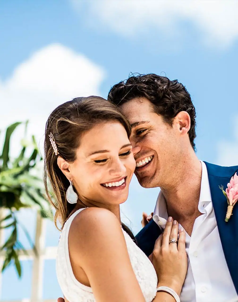 Smiling bride and groom under a blue sky at Hard Rock Cancun
