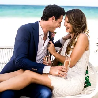 The couple smiling while holding champagne at Hard Rock Cancun, Cancun
