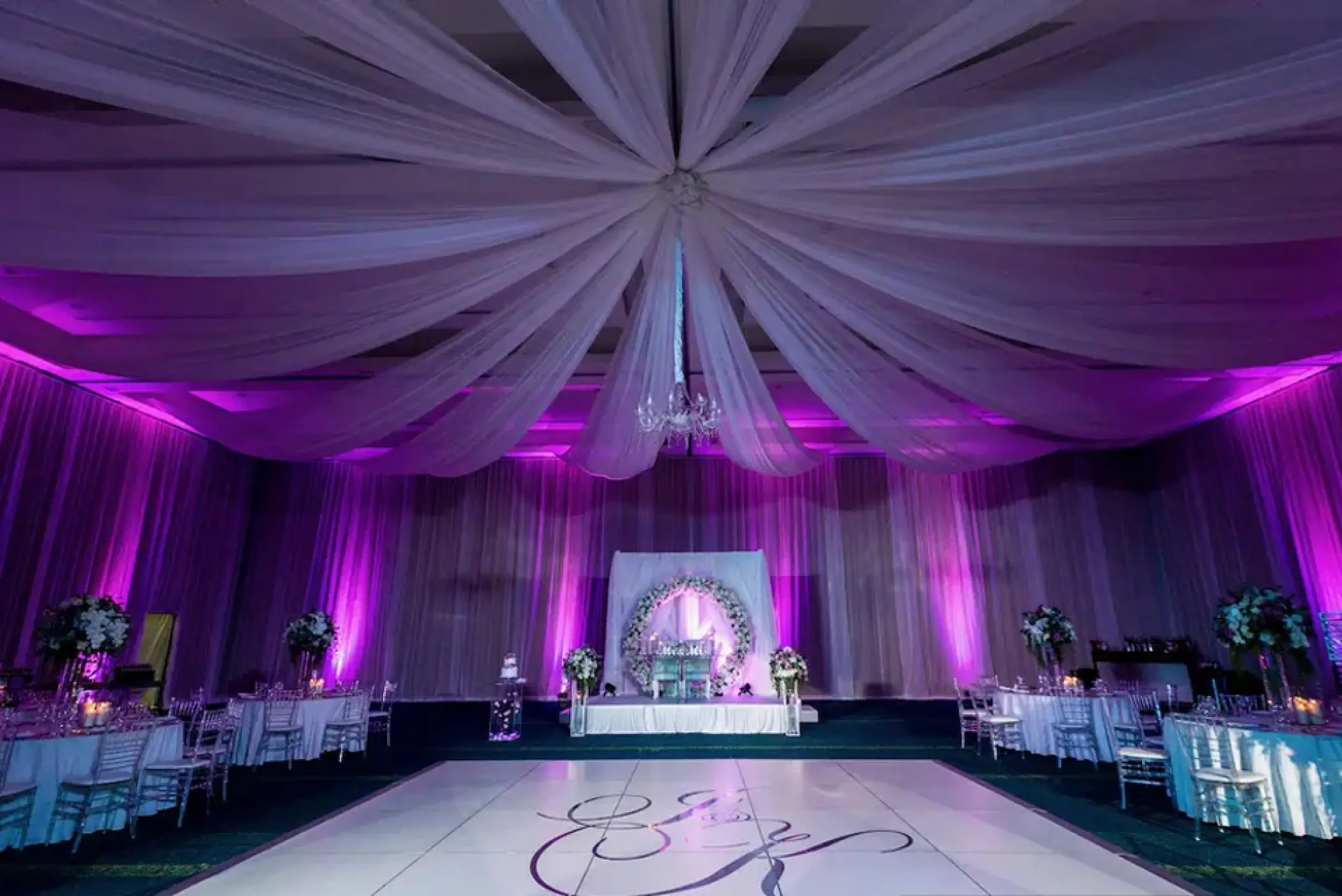 Indoor wedding reception ballroom with purple lighting and white draped ceiling at Hard Rock Hotel Punta Cana