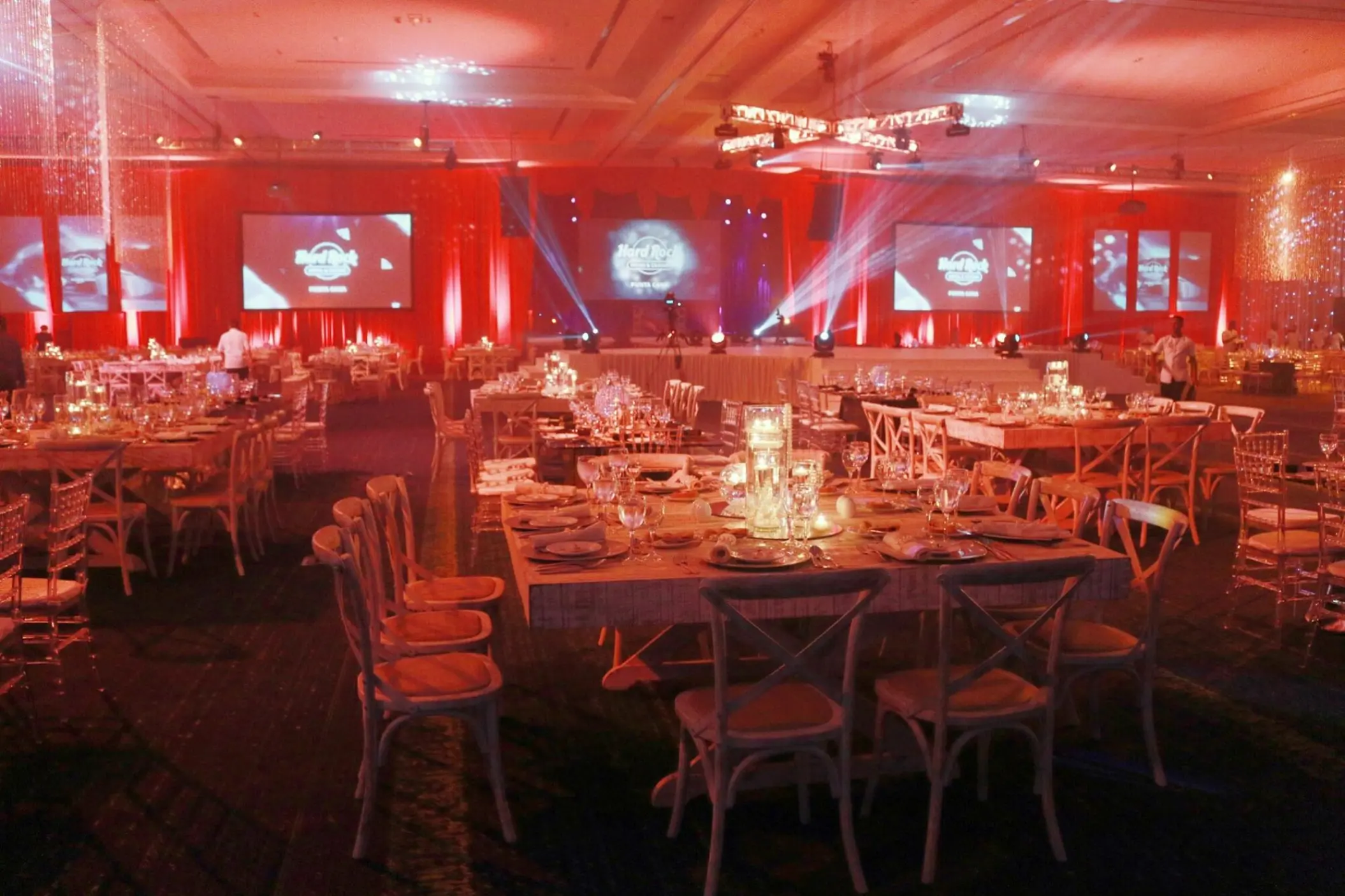 Indoor wedding reception with red lighting and concert screens in the ballroom at Hard Rock Punta Cana