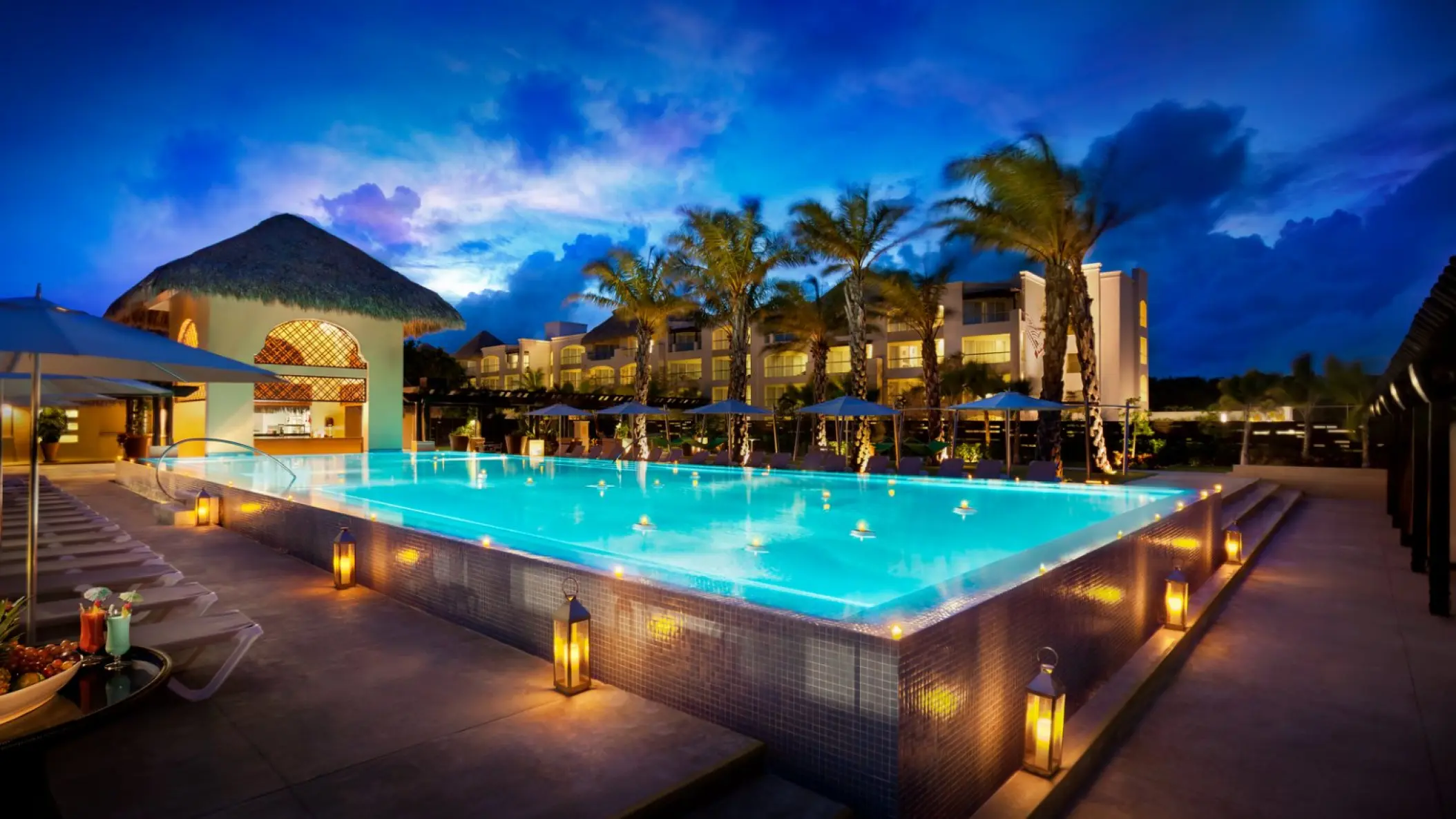 Hard Rock Punta Cana Eden pool illuminated at night with palm trees and lanterns, Punta Cana
