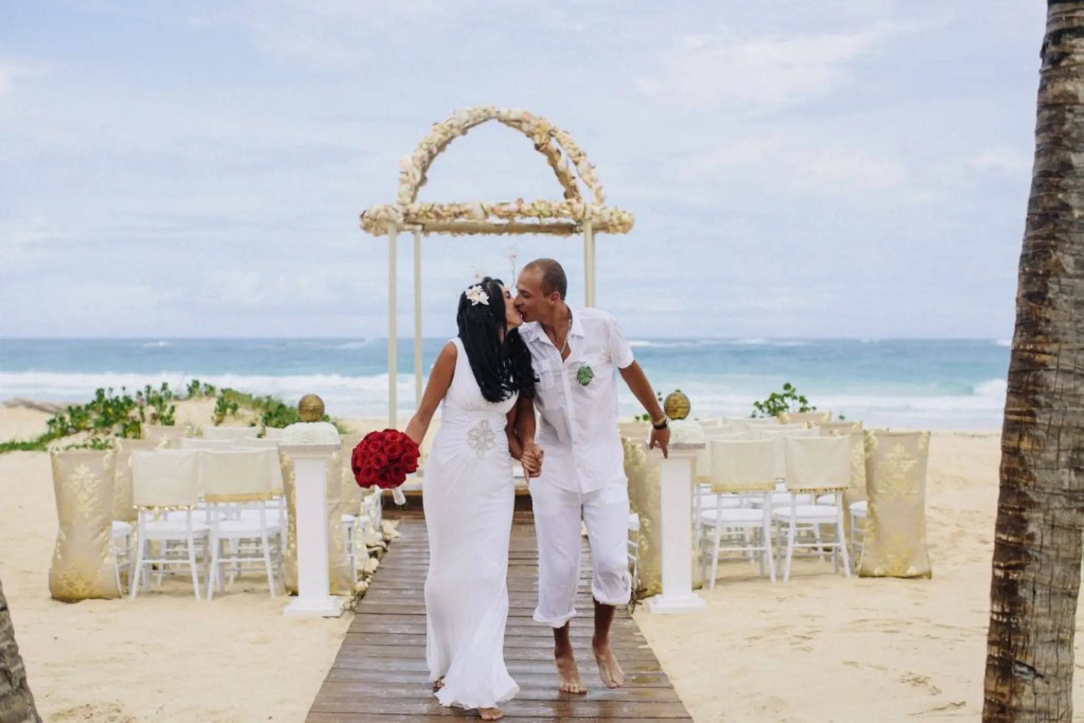 Bride and groom kissing during a beach ceremony at Hard Rock Punta Cana
