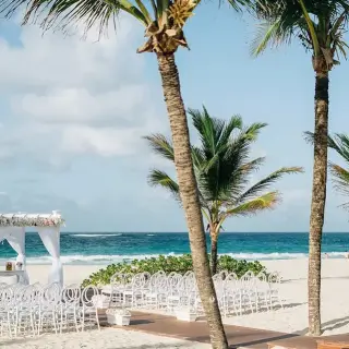 Beachfront wedding ceremony with white chairs and a floral gazebo at Hard Rock Punta Cana