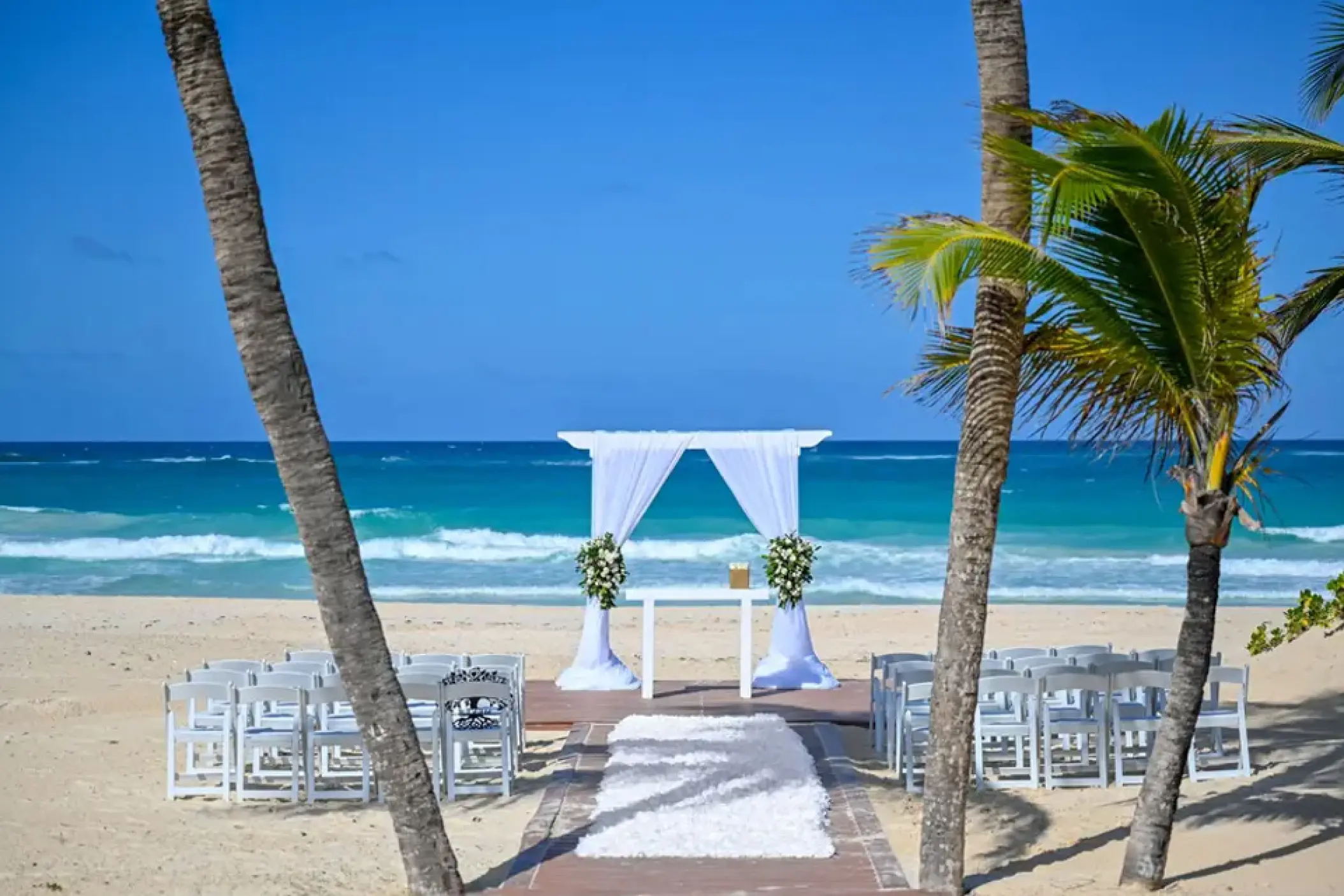 Beachfront wedding ceremony with a white fabric arch at Hard Rock Hotel Punta Cana