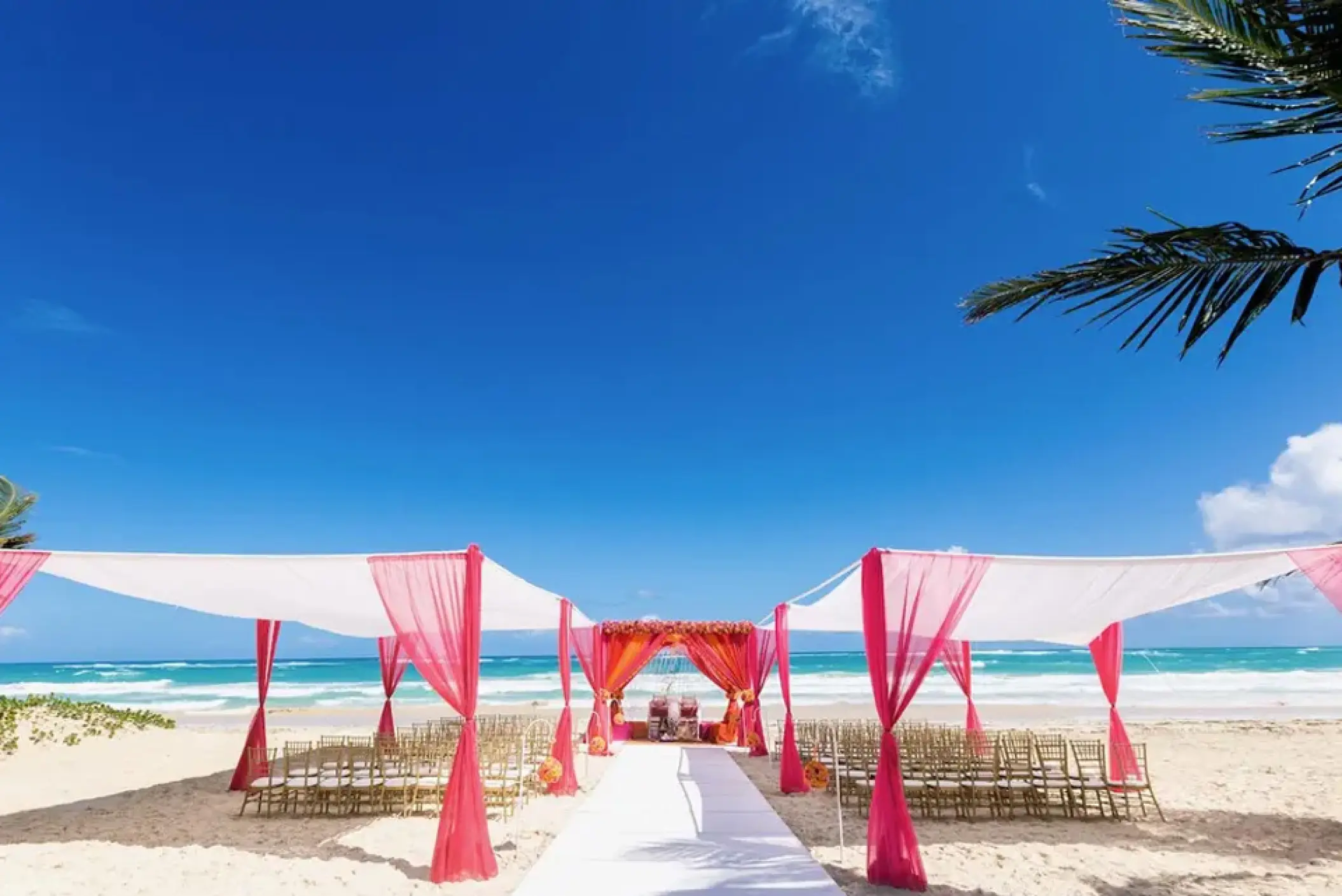 Beachfront wedding ceremony with pink and white canopies at Hard Rock Hotel Punta Cana, Punta Cana