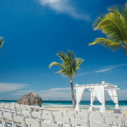 Beachfront wedding ceremony with white huppah and chairs at Hard Rock Punta Cana