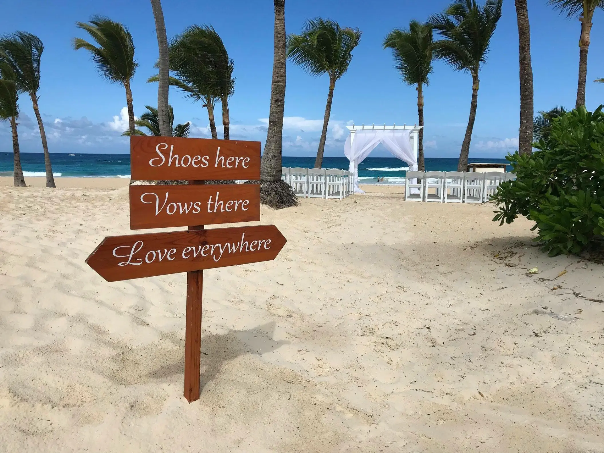 Wooden beach ceremony sign at Hard Rock Punta Cana with white gazebo and palm trees in the background