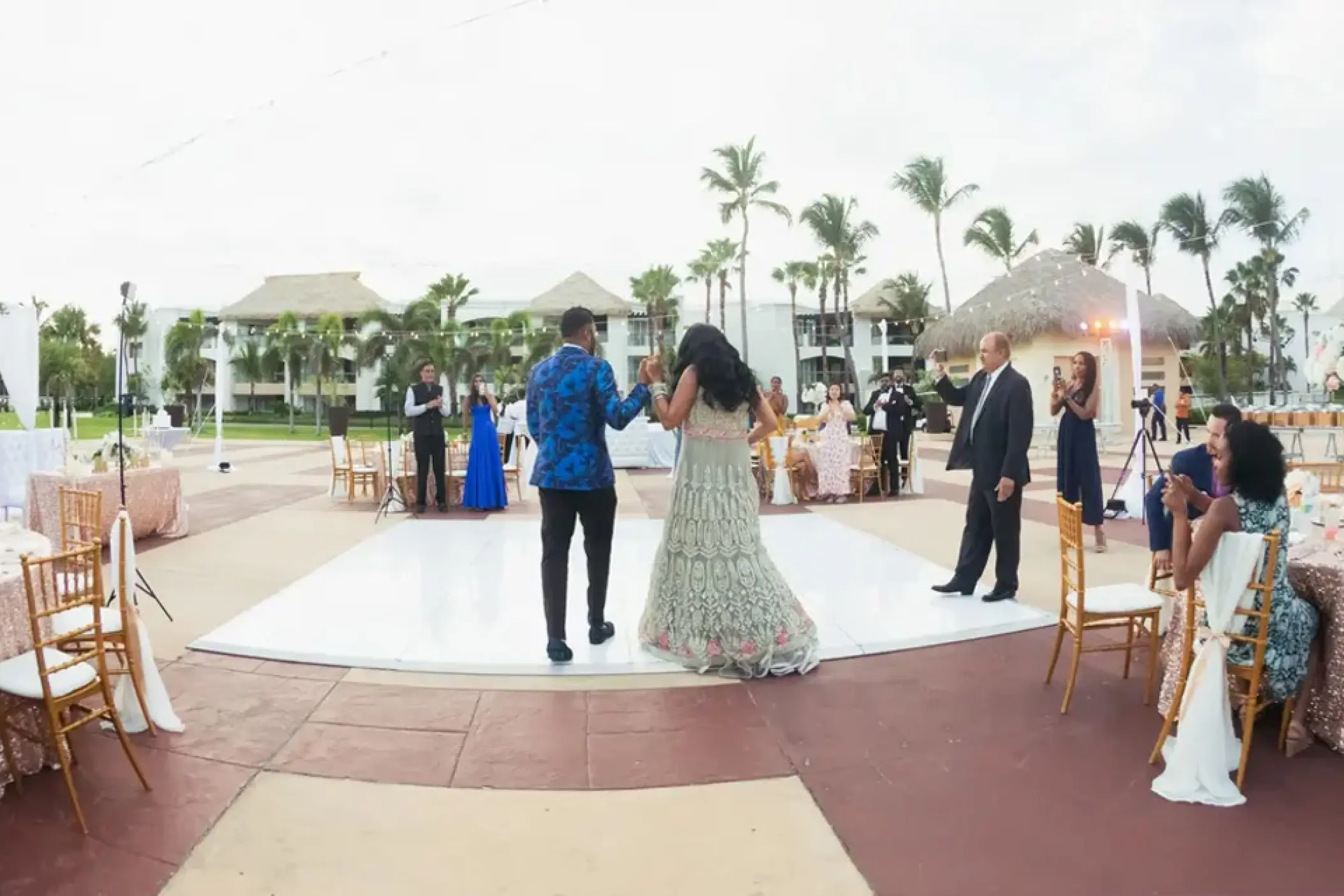 A couple walks onto an outdoor dance floor during a wedding reception at Hard Rock Punta Cana