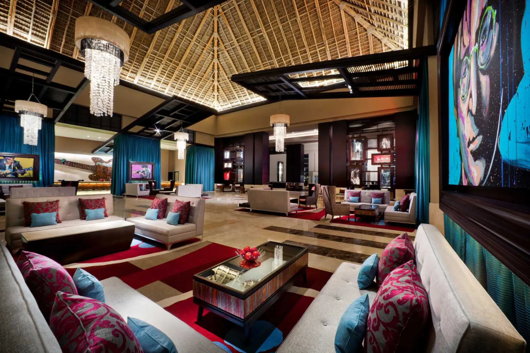 Modern lobby lounge with vaulted thatched ceiling and rock-themed art at Hard Rock Punta Cana