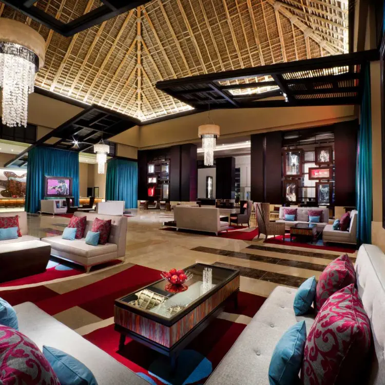 Modern lobby lounge with vaulted thatched ceiling and rock-themed art at Hard Rock Punta Cana