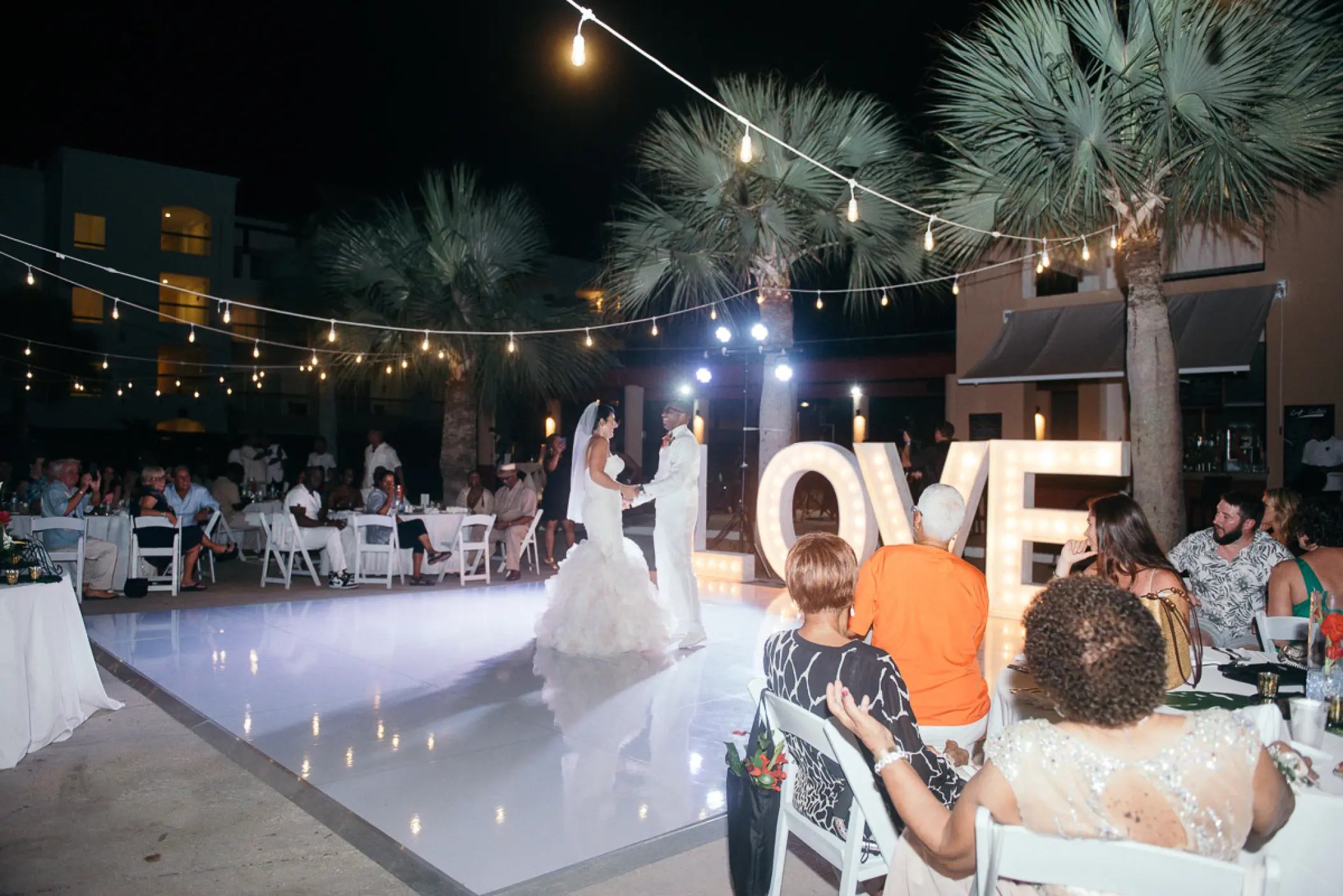 The couple dancing on a white dance floor by a large lit LOVE sign at Hard Rock Punta Cana