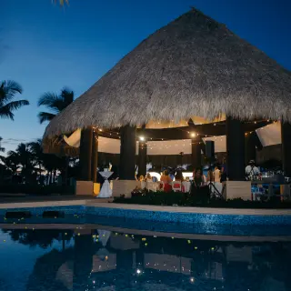 Evening wedding reception under the thatched Trumpet Gazebo at Hard Rock Punta Cana