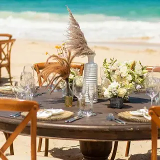 Beachfront wedding reception tables set up on the sand at Hard Rock Cancun