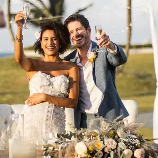 The bride and groom raising a champagne toast at Hard Rock Riviera Maya